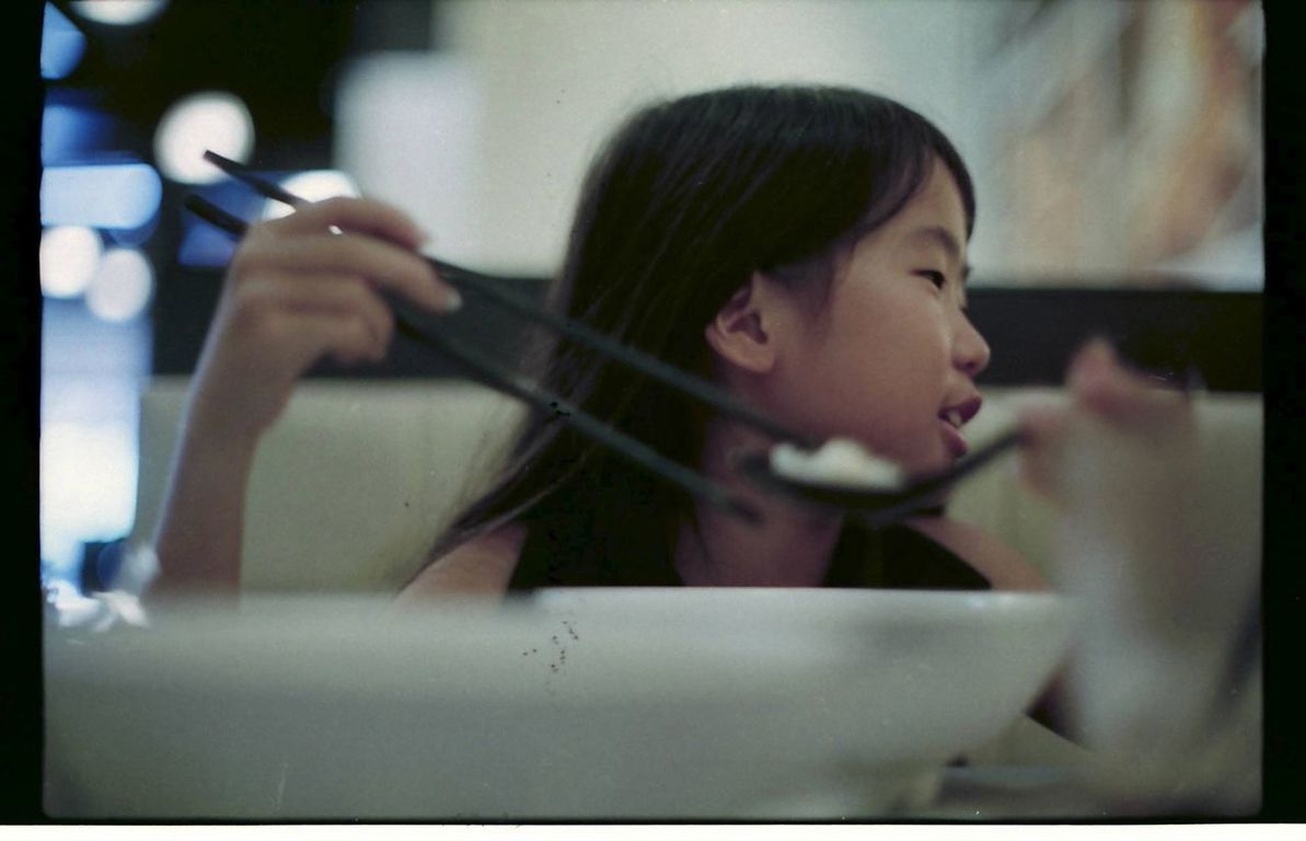 CLOSE-UP OF YOUNG WOMAN PLAYING WITH EYEGLASSES