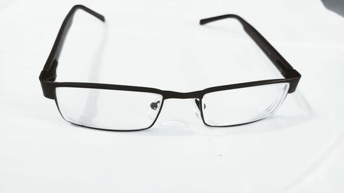 Close-up of eyeglasses on table against white background