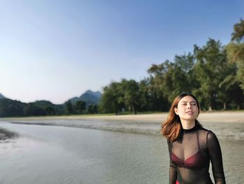 Portrait of woman standing against sky