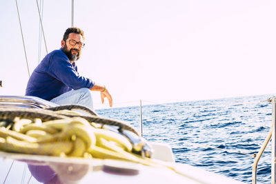 Man sailing on sea against clear sky