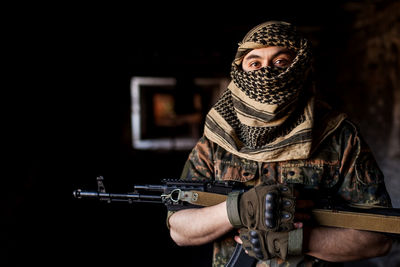 Portrait of serious middle eastern man with ak-47