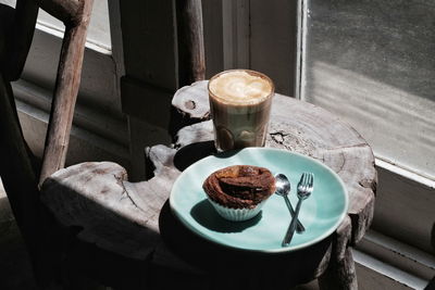 High angle view of dessert and coffee on tree stump