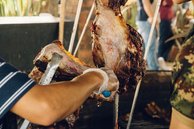 Close-up of man preparing food on barbecue grill