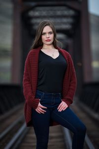 Portrait of beautiful young woman standing on railway bridge