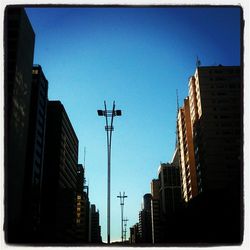 Low angle view of buildings against clear blue sky