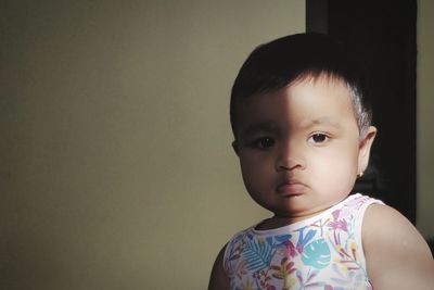 Portrait of cute girl against wall