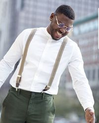 Midsection of man with arms raised standing outdoors