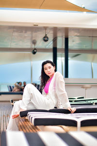 Young woman using mobile phone while sitting on table