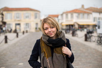 Portrait of young woman standing on street