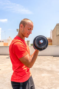 Side view of man exercising with dumbbell