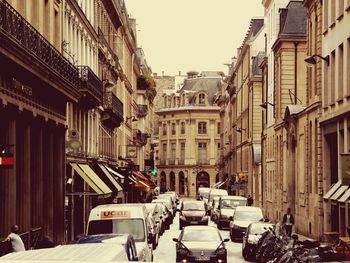 Cars on city street against sky