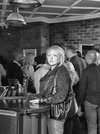 Portrait of a smiling young woman standing at nightclub