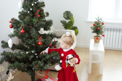 Portrait of cute girl decorating christmas tree at home