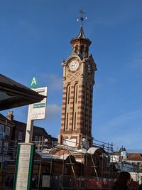 Low angle view of clock tower against blue sky