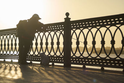 Low section of woman standing by railing
