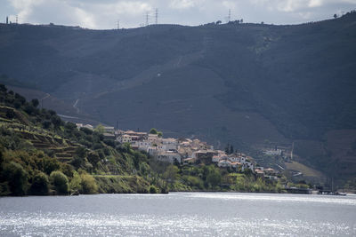 Scenic view of lake by mountains against sky