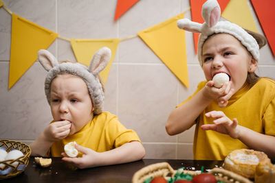 Children in rabbit ears eat easter eggs
