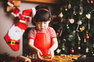 Girl preparing cookie at home during christmas