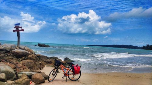 Bicycle on beach against sky