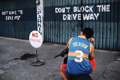 Rear view of man with text on road