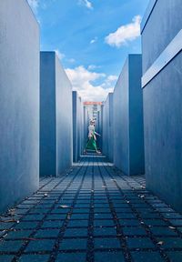 Rear view of man amidst buildings against sky in city