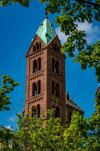 Low angle view of trees and building against sky