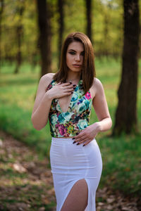 Beautiful young woman standing in a forest