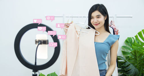 Smiling young woman standing against wall