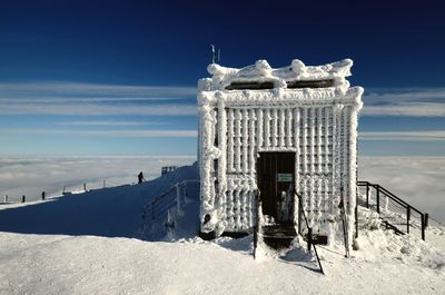 Built structure on snow covered landscape against sky