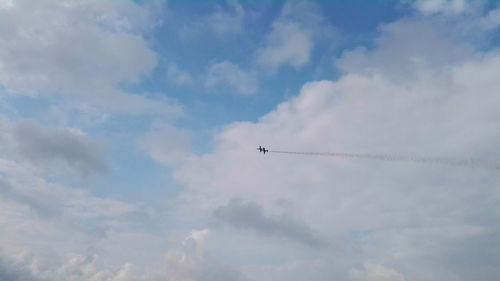 Low angle view of airplane flying against sky