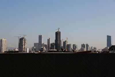 Modern buildings in city against clear sky