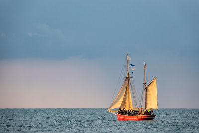 Sailboat sailing on sea against sky