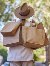 Rear view of woman wearing hat standing outdoors