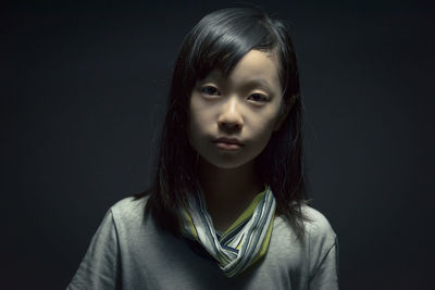 Close-up portrait of boy against black background