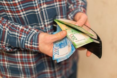 Midsection of man removing paper currencies from wallet