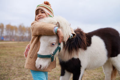 Happy girl hugging little pony