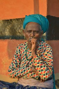 Portrait of a person in traditional clothing smoking