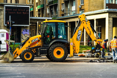 Vehicles on road against buildings in city