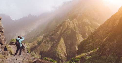 Rear view of man standing against mountains