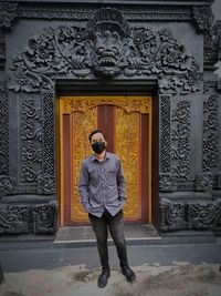 Full length of man standing against building
