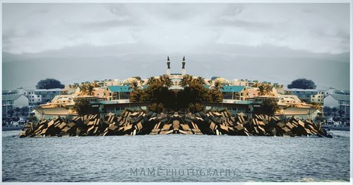 Buildings by sea against sky in city