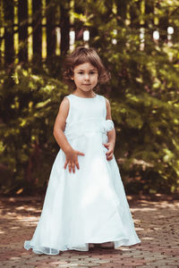 Portrait of girl standing against tree