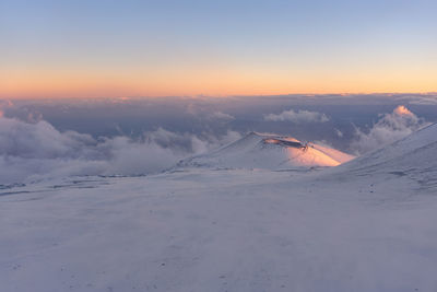 Scenic view of snow covered landscape against sky during sunset