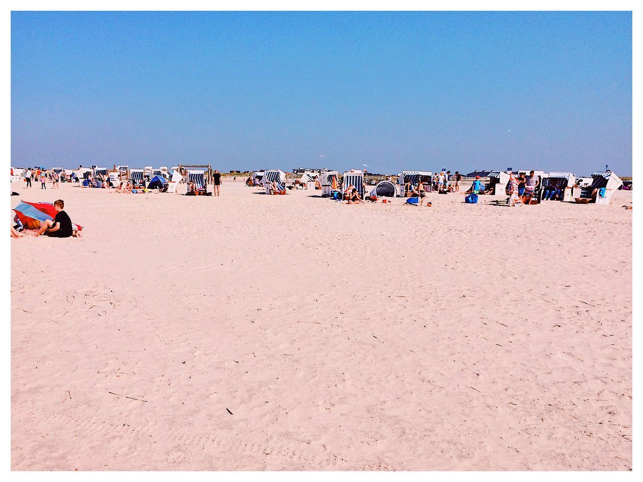 CROWD ON BEACH AGAINST CLEAR SKY