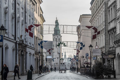 People on street amidst buildings in city