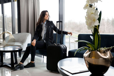 Woman sitting on table by window