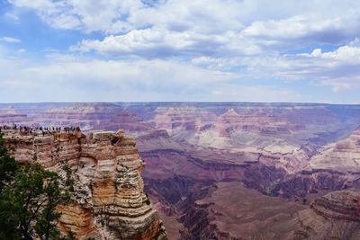 Rock formations on landscape against cloudy sky