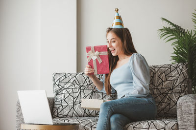 Young woman sitting on sofa at home