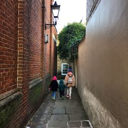 Rear view of people walking on building