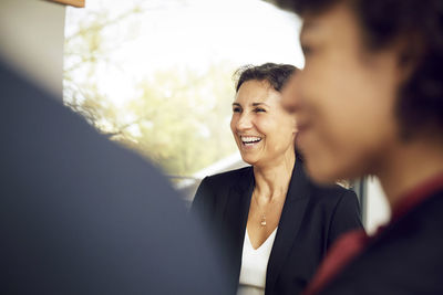 Smiling mature businesswoman in meeting with colleague at office